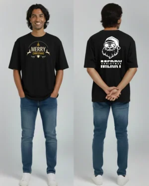 Sri Lankan male model wearing a black oversized Merry Christmas t-shirt with gold reindeer and tree graphic on the front, paired with blue jeans and white sneakers, shown from the front.